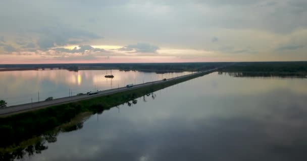 Zonsondergang vanaf de bovenkant van de rivier met een brug — Stockvideo