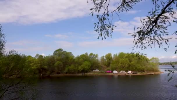 Belle vue sur la rivière à travers les arbres, reflet des nuages sur l'eau 