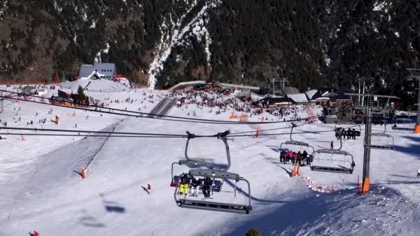 Panorama horizontal. Beaucoup de gens commencent à skier sur une piste de ski bien entretenue dans une station de ski. Le soleil brille et le ciel est clair et lumineux — Video