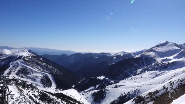 Panorama pozioma. Wiele osób rozpoczyna jazdę na nartach na dobrze przygotowanych stokach narciarskich w ośrodku narciarskim. Słońce świeci i niebo jest jasne i jasne — Wideo stockowe