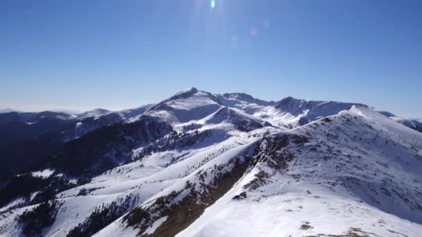 파노라마 수평. 많은 사람들이 스키 리조트에서 잘 손질 스키 슬로프에서 스키를 시작 합니다. 태양이 빛나고 하늘이 밝고 선명 합니다. — 비디오