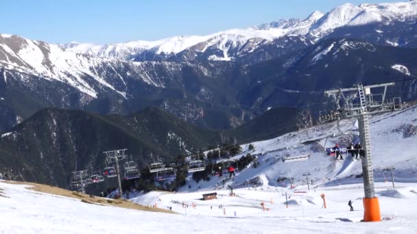 Panorama horizontaal. Veel mensen beginnen te skiën op een goed geprepareerde skipiste in een skigebied. De zon schijnt en de lucht is helder en helder — Stockvideo