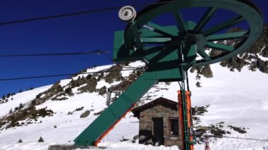 Panorama yatay. Birçok kişi, kayak beldesinde iyi bakımlı bir kayak pistine kayak yapmaya başlar. Güneş parlıyor ve gökyüzü parlak ve açık