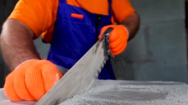 İşçi bir apartman onarımı yapar, plakaları keser