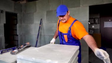 bir işçi bir daire onarım yapar, bir mezura ile önlemler