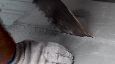 İşçi bir apartman onarımı yapar, plakaları keser