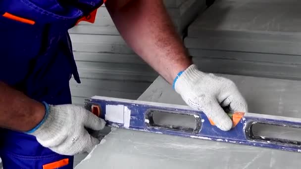 Un trabajador hace una reparación de apartamentos, medidas con una cinta métrica — Vídeos de Stock