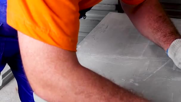 En arbejdstager gør en lejlighed reparation, foranstaltninger med et målebånd – Stock-video
