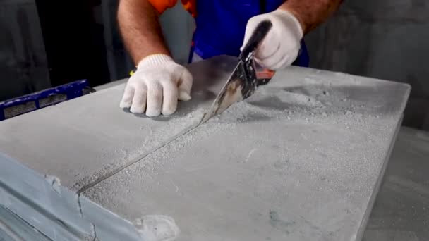 Werknemer maakt een appartement reparatie, snijdt platen — Stockvideo