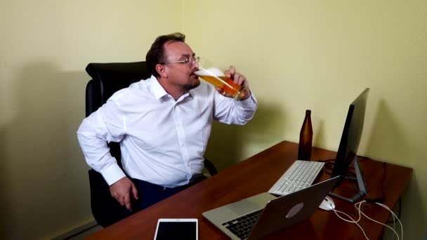 Kancelářský pracovník pije pivo po dokončení práce — Stock video