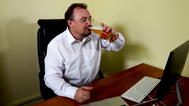 Kancelářský pracovník pije pivo po dokončení práce — Stock video