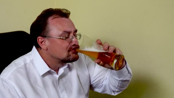 Office worker drinks beer after finishing work — Stock Video