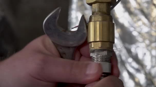 Loodgieter ontschroef een moersleutel om een moer op een waterleiding te schroeven — Stockvideo