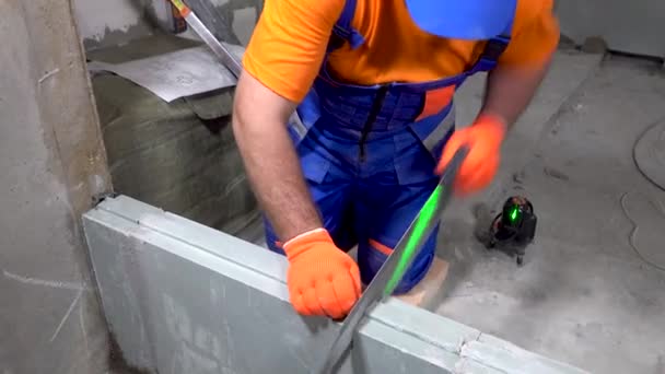 Reparatur in der Wohnung, ein Bauarbeiter sägt Gipskartonblöcke — Stockvideo