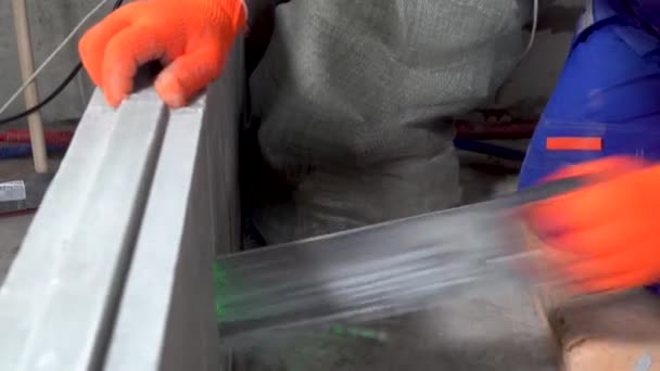 Repair in the apartment, a construction worker sawing plasterboard blocks — Stock Video