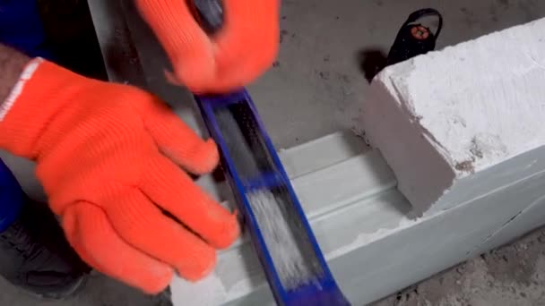 Constructor muele un bloque de placas de yeso con una cepilladora, apartamento o reparación del hogar — Vídeo de stock