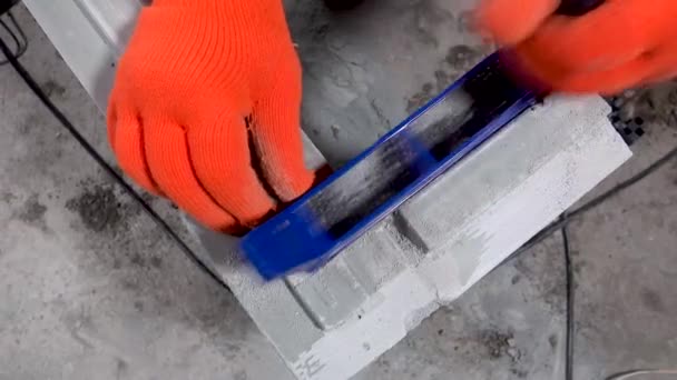 Constructor muele un bloque de placas de yeso con una cepilladora, apartamento o reparación del hogar — Vídeo de stock