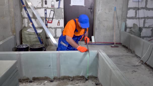 Reparatur in der Wohnung, ein Bauarbeiter sägt Gipskartonblöcke — Stockvideo