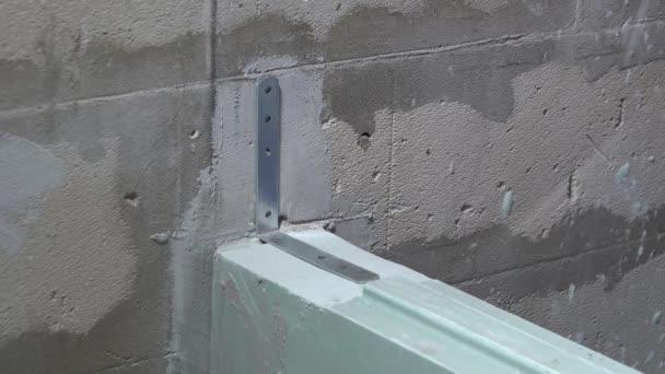 Worker screws a corner to the wall with a screwdriver — Stock Video