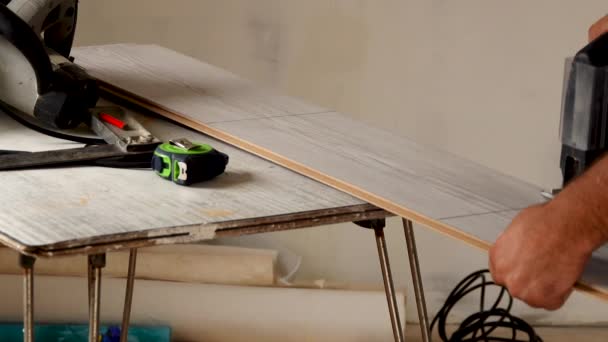 Work saws a laminate with an electric jigsaw — Wideo stockowe