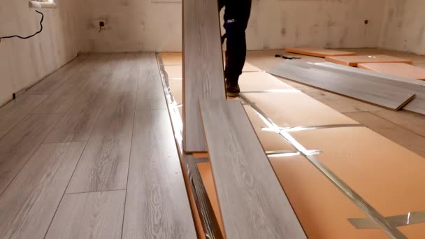 Trabalhador está colocando piso laminado em um apartamento — Vídeo de Stock