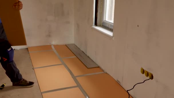 Travailleur pose stratifié plancher dans un appartement — Video