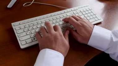 Genç adam şirketin müdürü ofiste oturur ve klavye de türleri