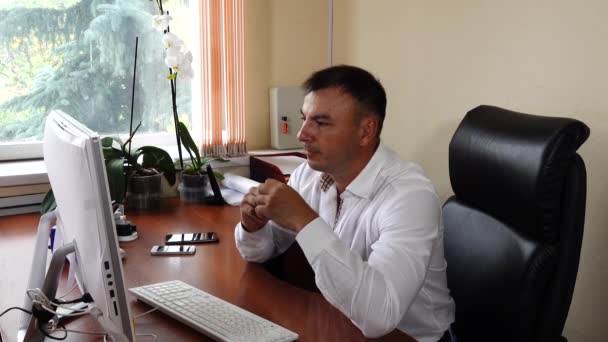 The young man the director of the company sits in the office and emotionally works, very pleased with his work — Stockvideo