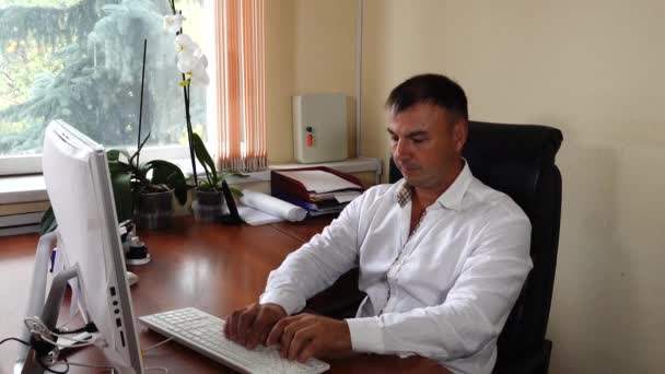 The young man the director of the company sits in the office and emotionally works, very pleased with his work — Stockvideo