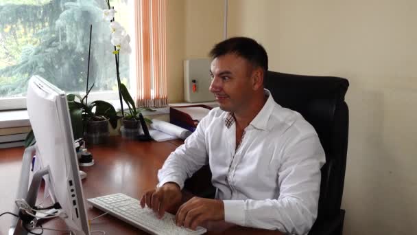 The young man the director of the company sits in the office and emotionally works, very pleased with his work — Stockvideo