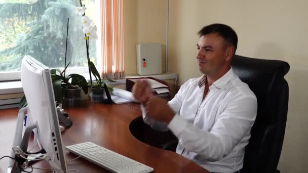 The young man the director of the company sits in the office and emotionally works, very pleased with his work — Stockvideo