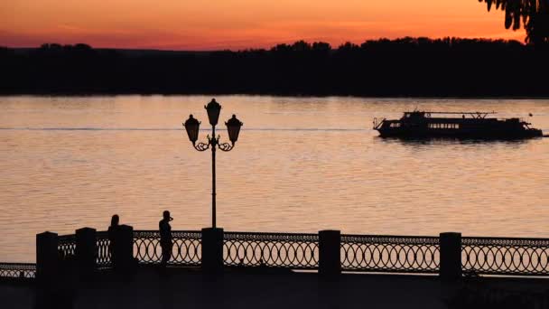 Ufer des Flusses bei Sonnenuntergang, Silhouette der Promenade — Stockvideo