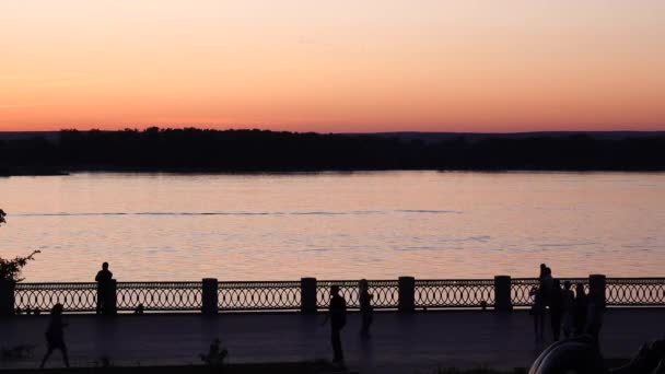 Dijk van de rivier bij zonsondergang, silhouet van de promenade — Stockvideo