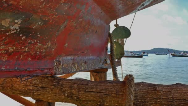 在一艘老渔船后面的风景日出在拉威 Beachboat 螺旋桨在海滩的老渔船修理的尾巴 — 图库视频影像