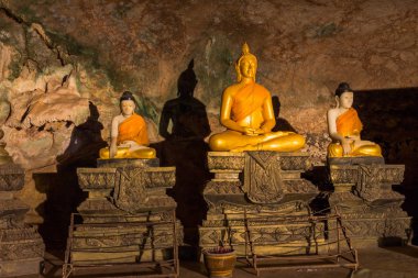 mağara içinde duvar boyunca Altın Buda heykelleri