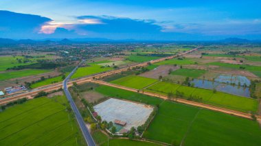 havadan görünümü sahne günbatımı pirinç alan içinde yeni yol geçmektedir. yapım aşamasında yeni otoyol bağlanmak için Myanmar.