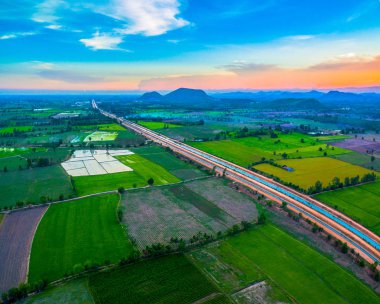 havadan görünümü sahne günbatımı pirinç alan içinde yeni yol geçmektedir. yapım aşamasında yeni otoyol bağlanmak için Myanmar.