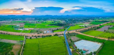 havadan görünümü sahne günbatımı pirinç alan içinde yeni yol geçmektedir. yapım aşamasında yeni otoyol bağlanmak için Myanmar.