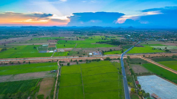 havadan görünümü sahne günbatımı pirinç alan içinde yeni yol geçmektedir. yapım aşamasında yeni otoyol bağlanmak için Myanmar.