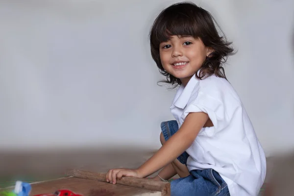 Menino Cabelo Longo Camisa Branca Jean Brincando Brinquedo Chão — Fotografia de Stock