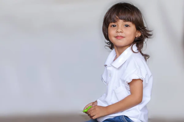 Menino Cabelo Longo Camisa Branca Jean Brincando Brinquedo Chão — Fotografia de Stock