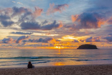 Kata Beach Phuket 'teki Pu adasının arkasında güzel bir günbatımı. Birçok turist gün batımında plajda dinlenir..