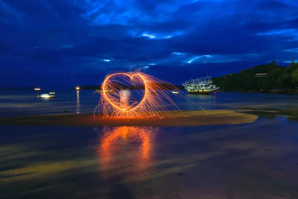 reflection of spark fire swirl from steel wool with long exposure speed motion abstract at sunrise in the se