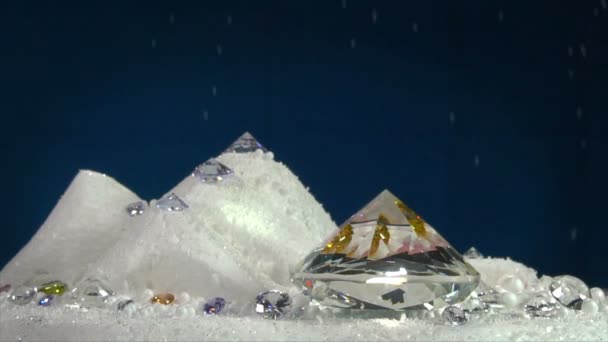 慢动作五颜六色的钻石在转动陈列柜以下雪的背景 — 图库视频影像