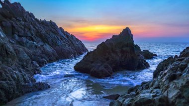 dalgalar büyük konik şekil rock taş cape ortasında günbatımı sırasında banana beach Phuket adlı hit