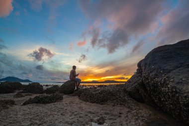 deniz bir adam selfie kayanın üzerine yukarıda gündoğumu 