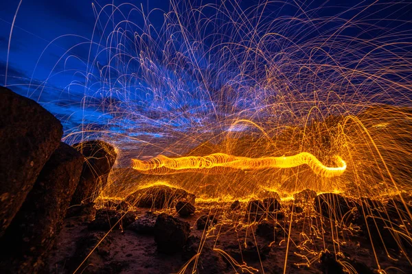 cool burning steel wool fire work photo experiments on the rock at sunrise