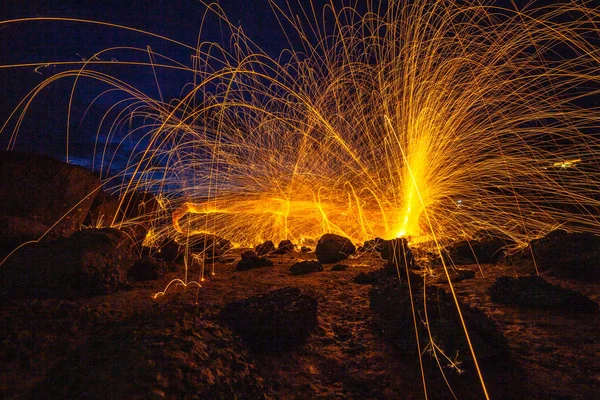 cool burning steel wool fire work photo experiments on the rock at sunrise