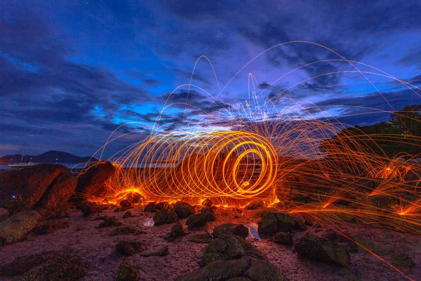 cool burning steel wool fire work photo experiments on the rock at sunrise