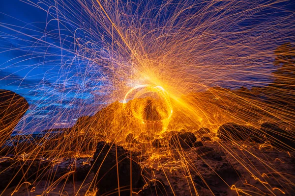 cool burning steel wool fire work photo experiments on the rock at sunrise